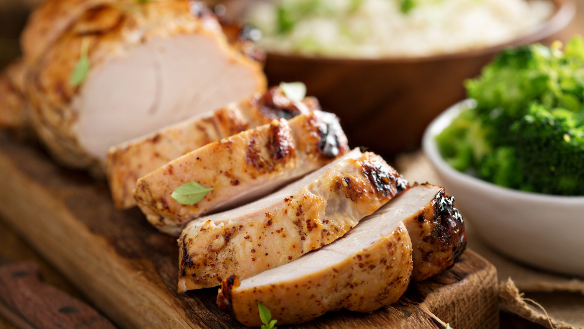 Oven-roasted turkey breast on cutting board with broccoli