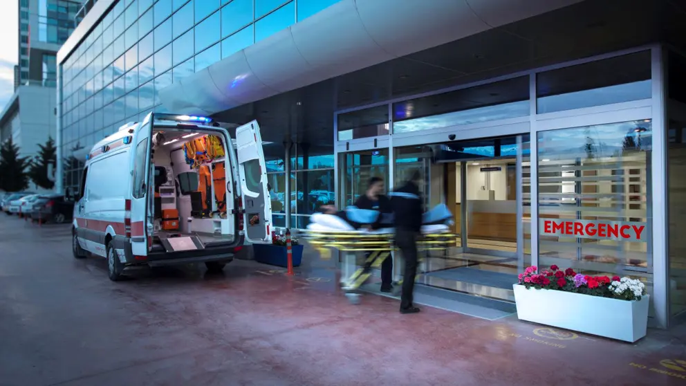 Des ambulanciers déplacent une personne sur une civière.