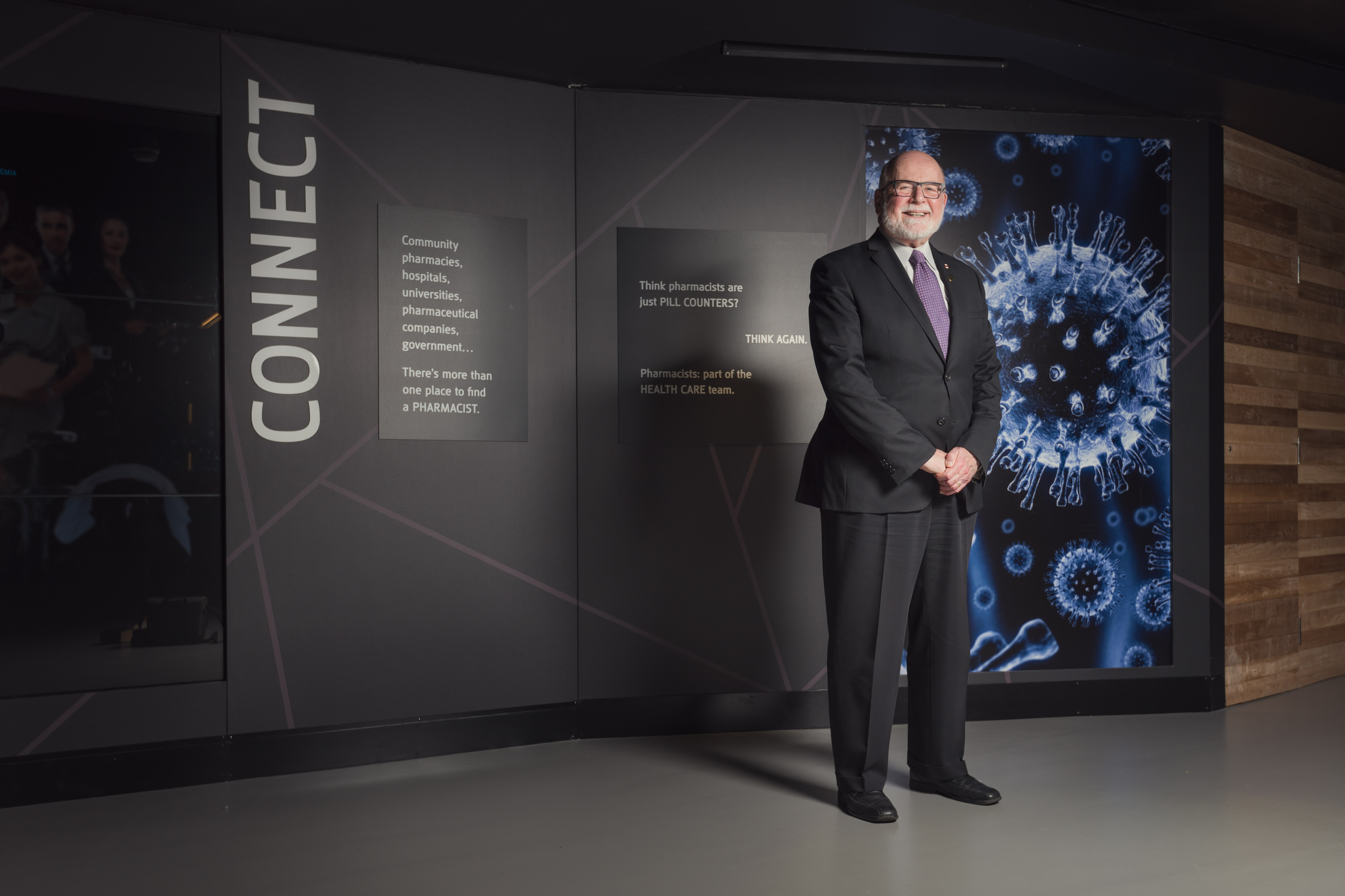 Le Dr John McNeill devant un présentoir.