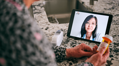 Une personne âgée discute avec une médecin par vidéoconférence lors d’un rendez-vous virtuel.