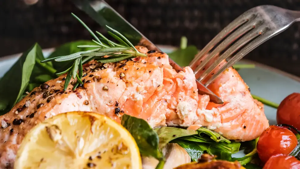Une assiette de saumon avec un couteau et une fourchette