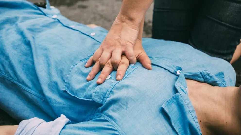 Mains pratiquant la RCR sur la poitrine d’un homme