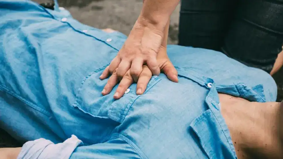 Mains pratiquant la RCR sur la poitrine d’un homme