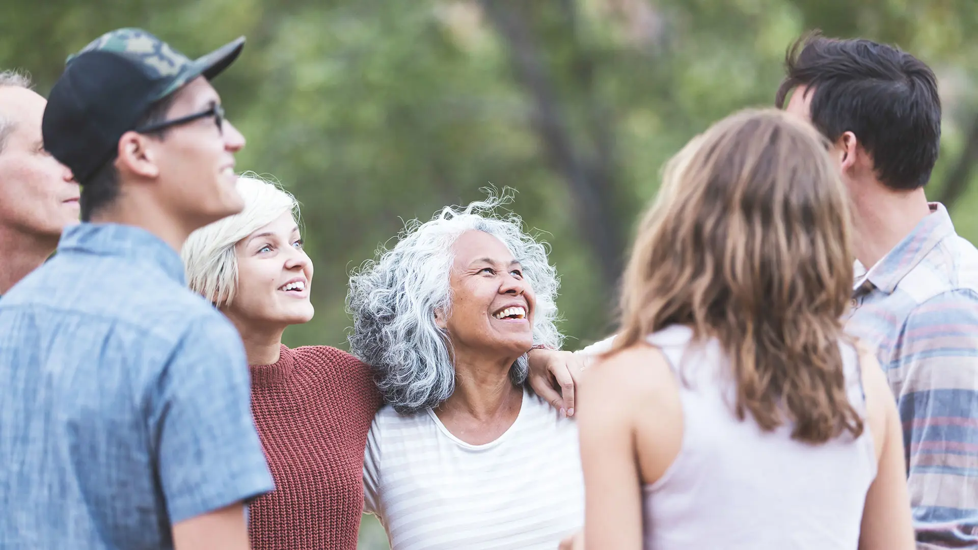 Groupe souriant de personnes parlant ensemble à l'extérieur