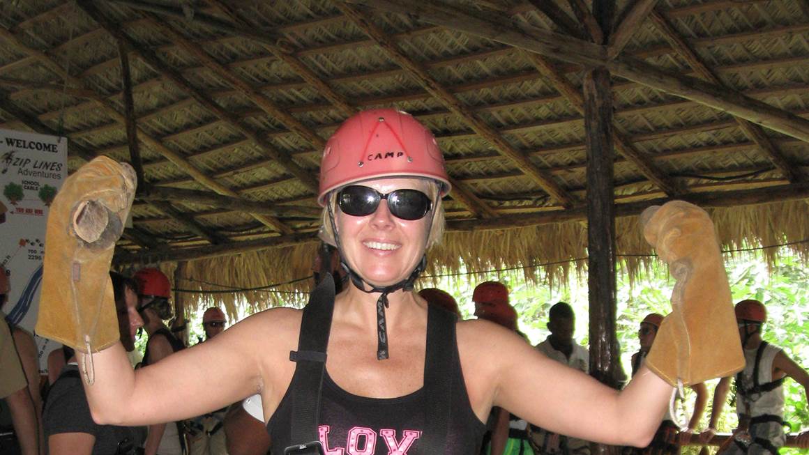 Beth Luhowy, le sourire aux lèvres, porte fièrement un casque rose et un harnais de sécurité.