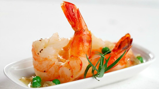 Crevettes cuites et petits pois servis sur assiette blanche