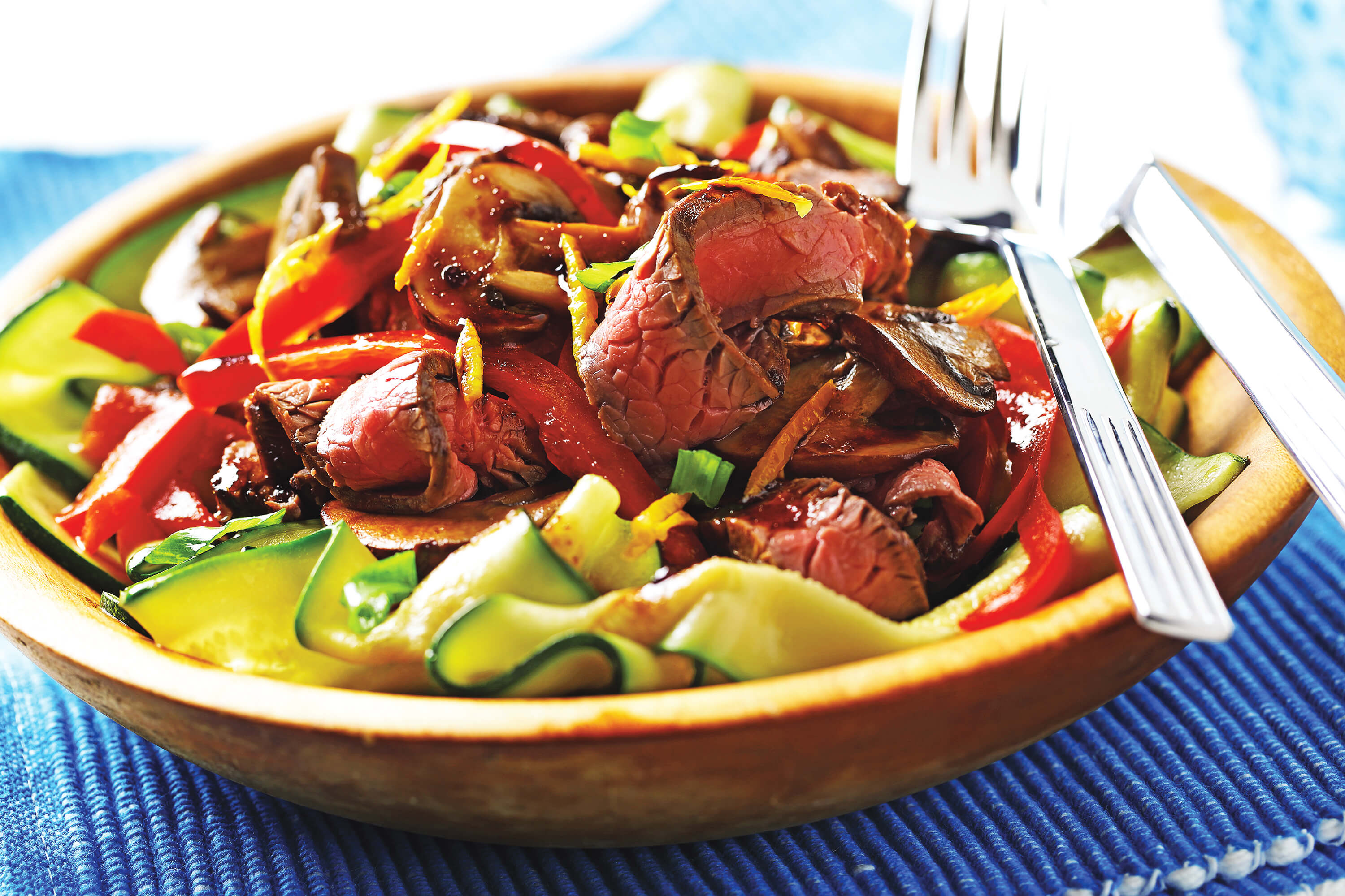 Tranches de bœuf, courgettes et poivrons rouges dans un bol