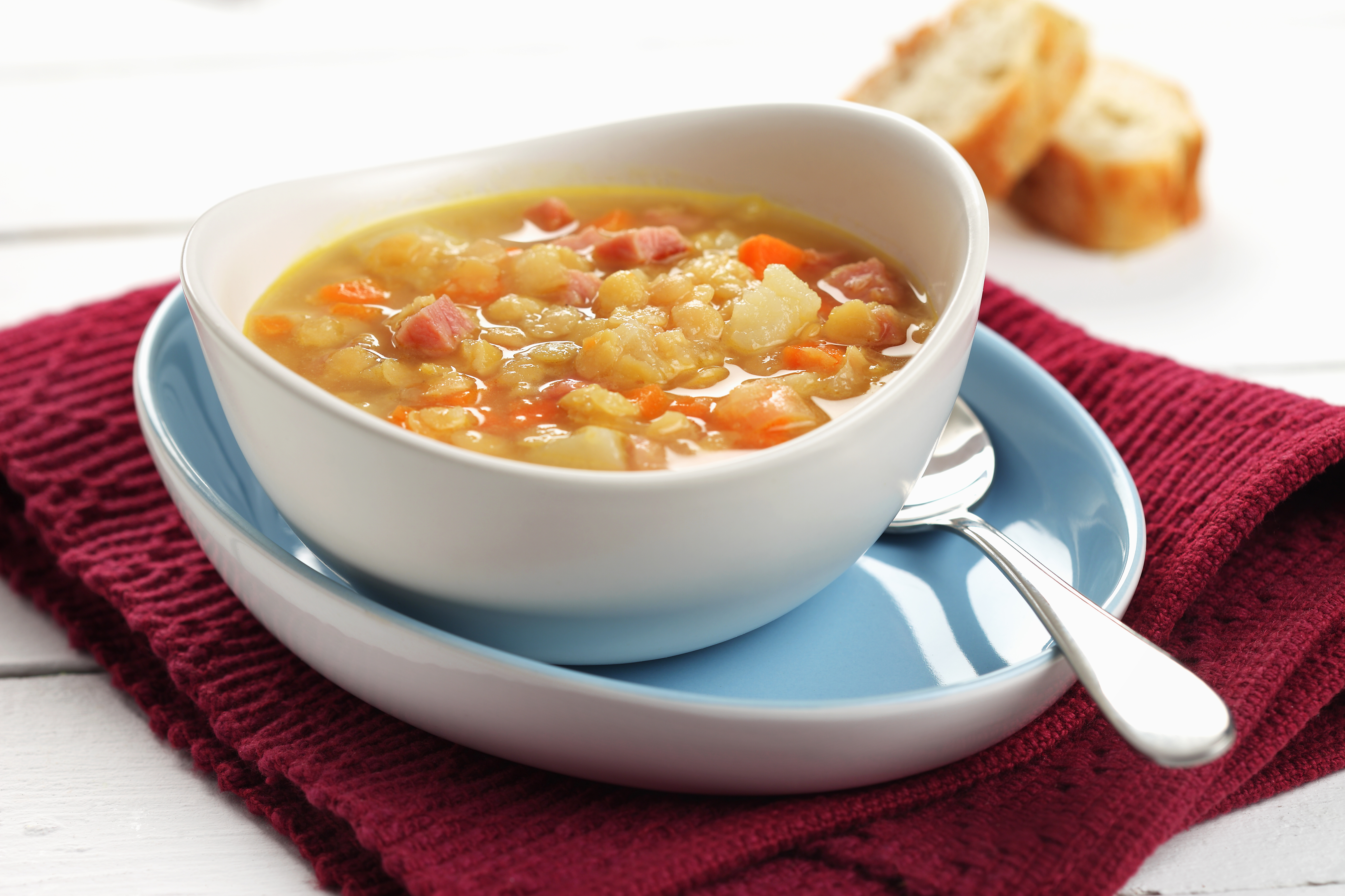 Soupe aux pois à l’ancienne dans un bol blanc sur une serviette de table rouge.