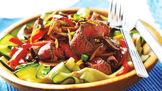 Tranches de bœuf, courgettes et poivrons rouges dans un bol