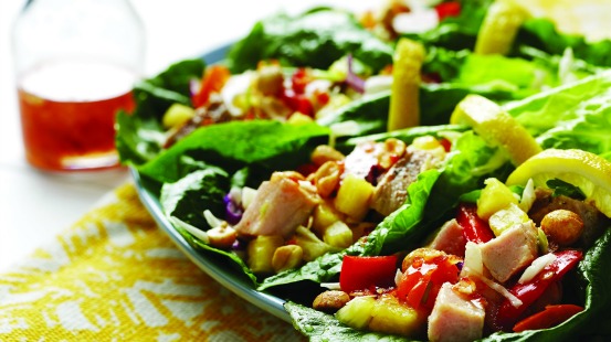 Poulet haché, poivrons rouges, ananas et arachides hachés sur une feuille de laitue