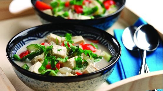 Bols de cubes de tofu, coriandre, poivron rouge, courgette et bouillon