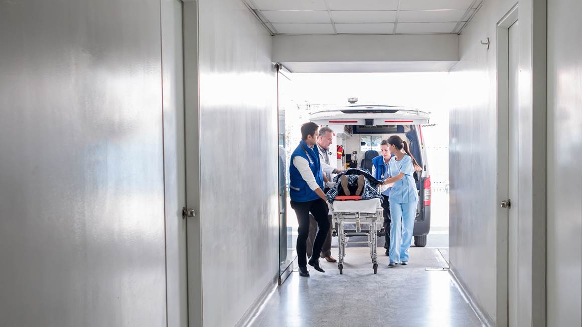  Une équipe médicale pousse un patient sur une civière dans un hôpital.