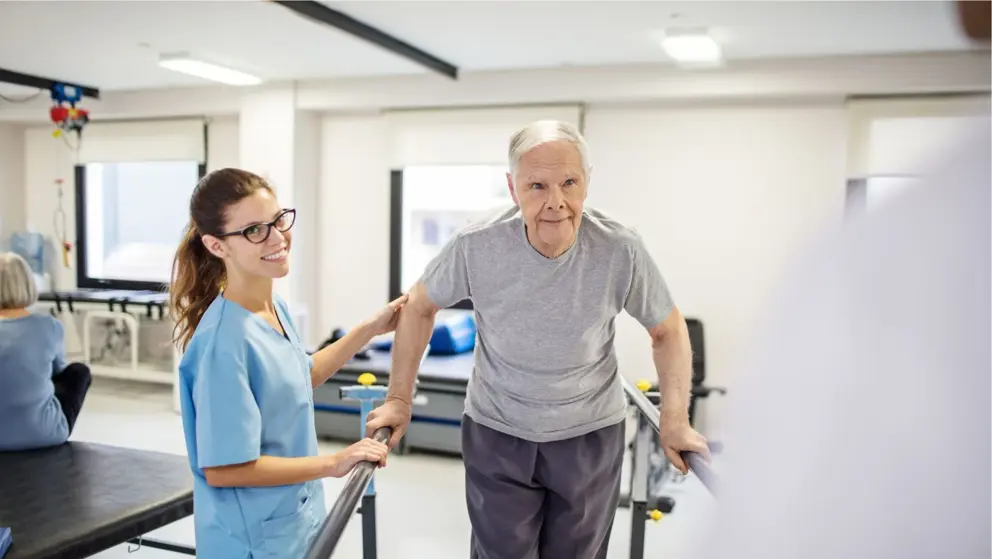  Une infirmière assistant un patient en réadaptation à marcher sur une plate-forme en pente.