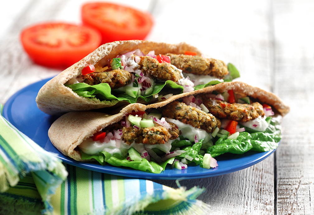 Pain pita rempli de falafel, de laitue, de tzatziki, de tomates, d'oignon et de concombre