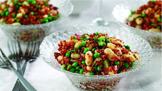 Bols en verre remplis de quinoa, de haricots cannellini, de pois et de coriandre