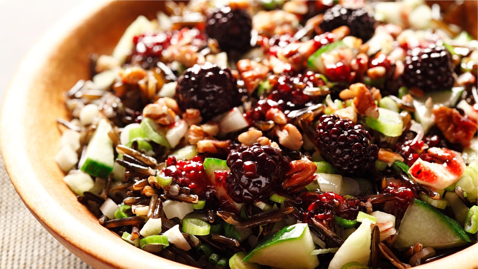 Salade croustillante de riz sauvage avec vinaigrette de mûre dans un bol de bois.