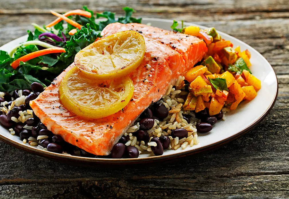 Assiette de truite grillée, salsa de mangue, riz, haricots noirs et salade verte