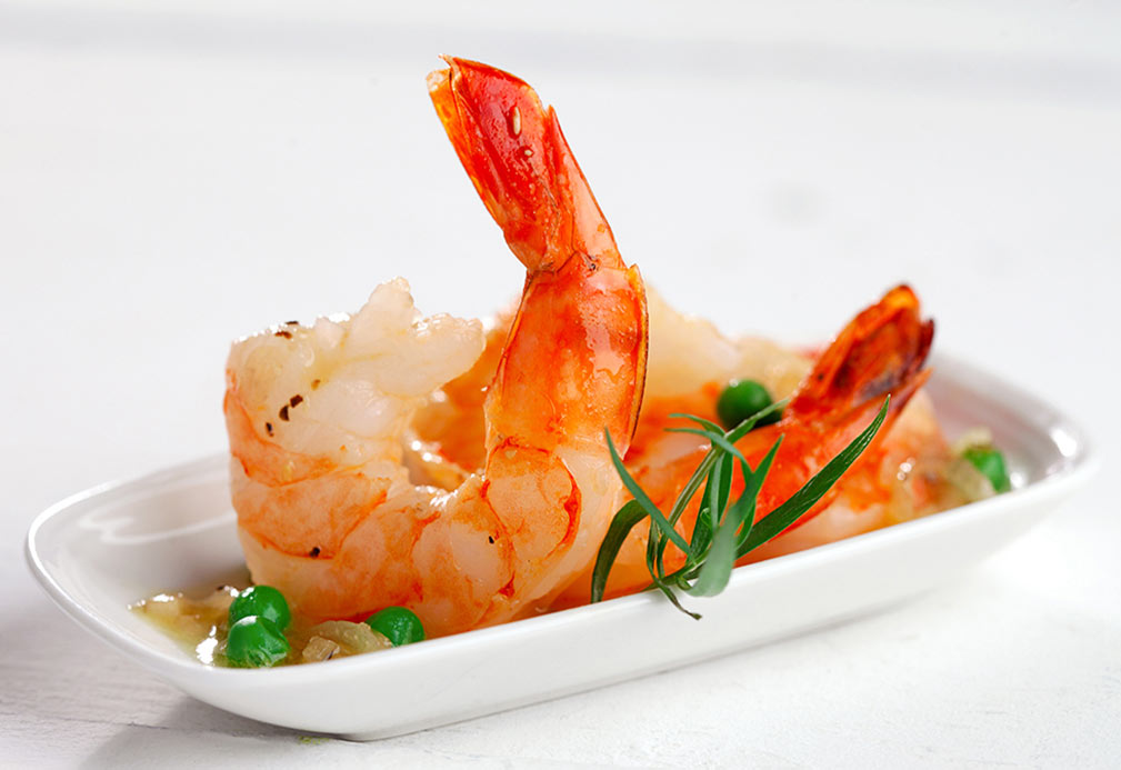 Crevettes cuites et petits pois servis sur assiette blanche