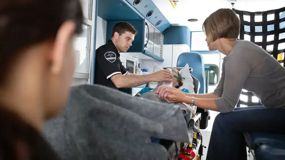 Senior femme étant donné l'oxygène dans un soignant d'ambulance à côté