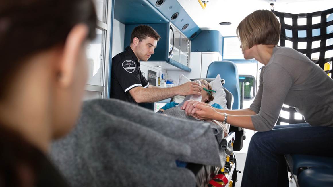 Senior femme étant donné l'oxygène dans un soignant d'ambulance à côté