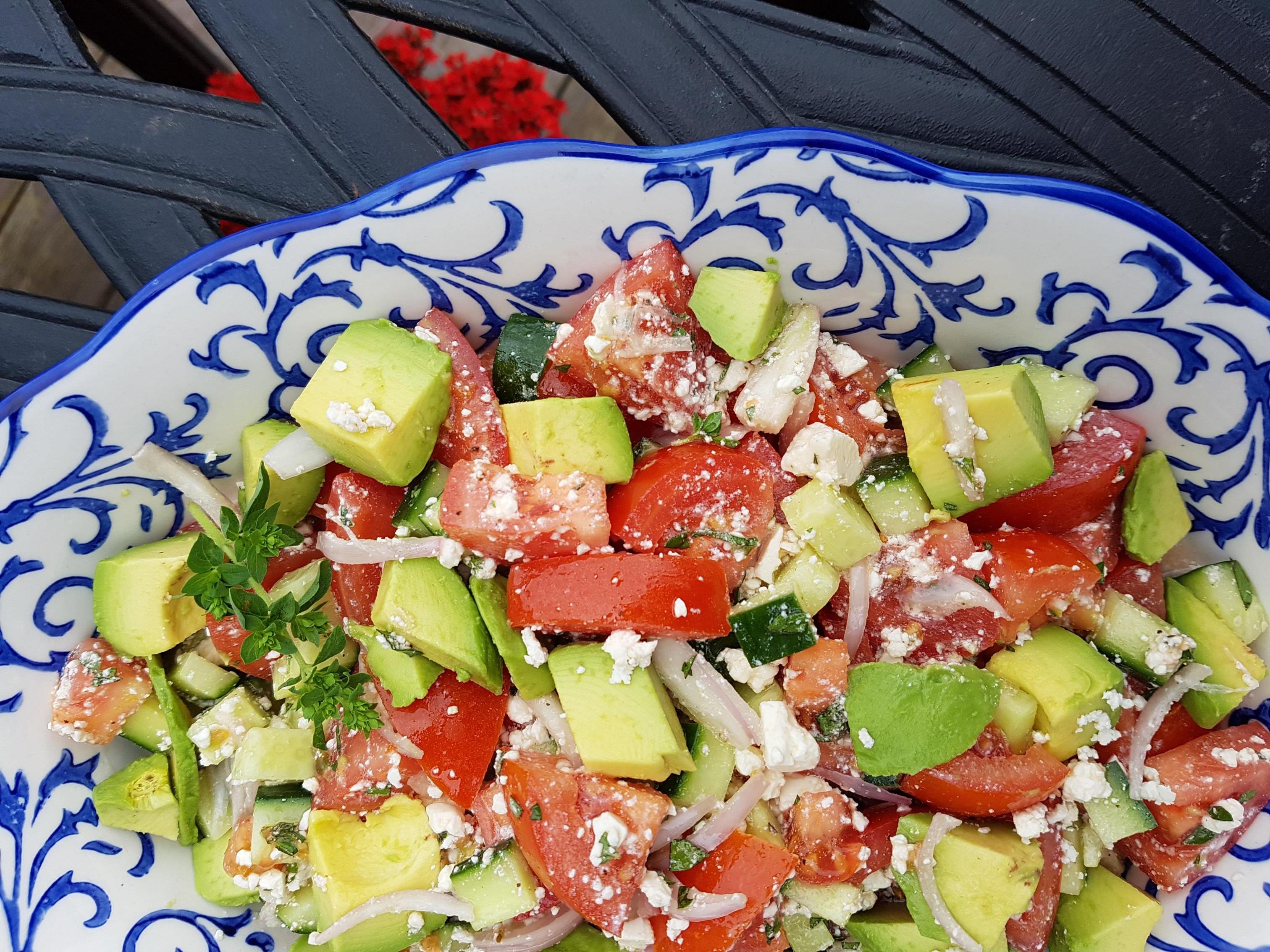Tomates hachées, avocat et feta sur assiette bleue et blanche