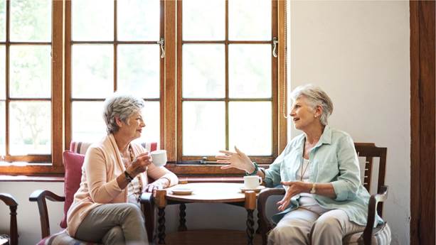 Deux femmes âgées parlent en prenant le thé