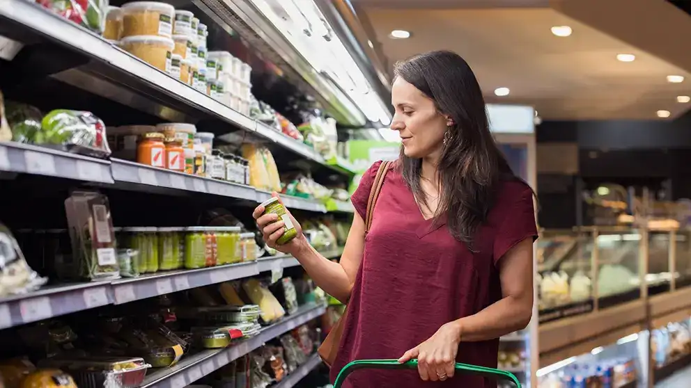 Une femme qui regarde des produits sur une étagère à l’épicerie