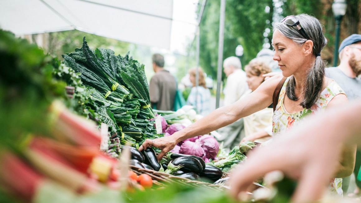 Femme achetant des légumes au marché des agriculteurs