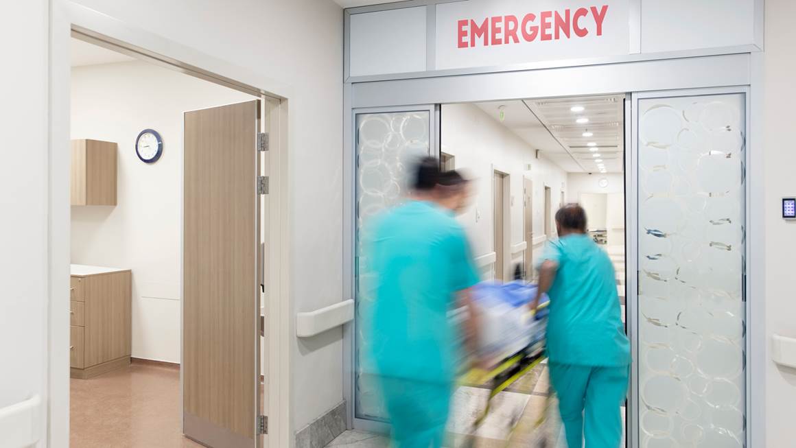 Les médecins poussent un patient sur une civière dans un couloir d'hôpital.