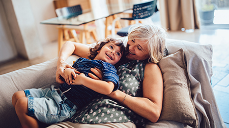 Une grand-mère et son petit-fils qui s’amusent ensemble dans la maison.