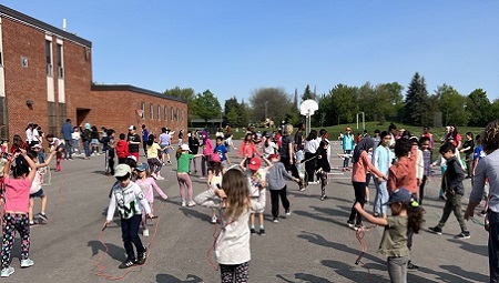 Enseignant tenant son ordinateur portable et saluant la caméra