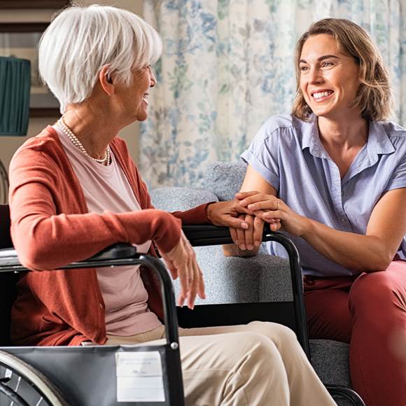 Une femme parlant avec une personne âgée en fauteuil roulant