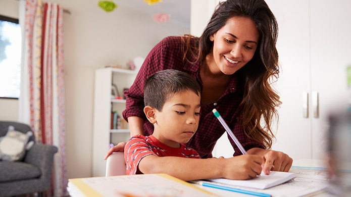 Un enfant et sa mère travaillent ensemble aux devoirs à la table de la cuisine.