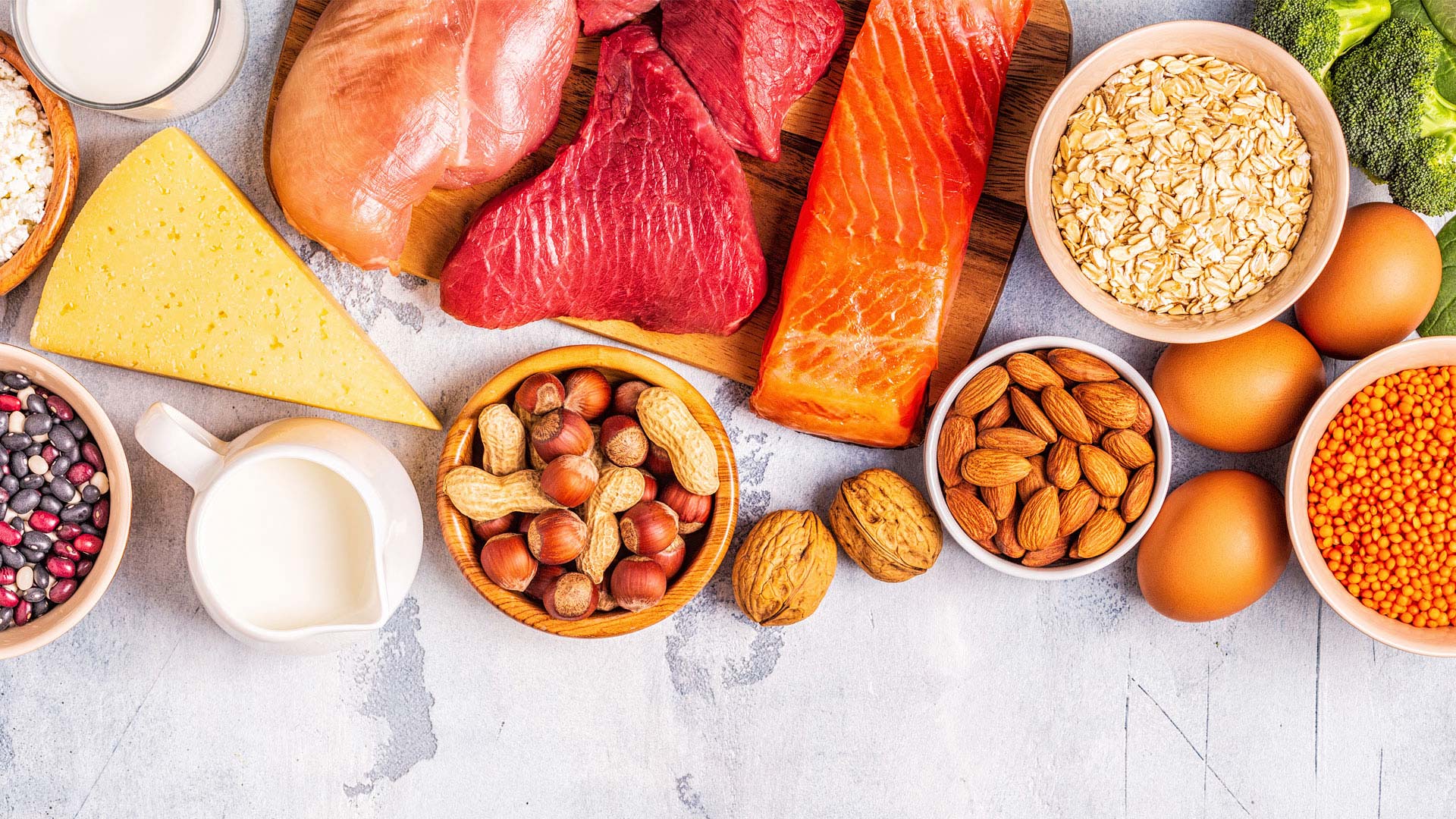 Un coup d’œil sur des ingrédients crus tels que des œufs, du saumon, du poulet, des graines, du lait, de la viande, du fromage, des amandes et des haricots.