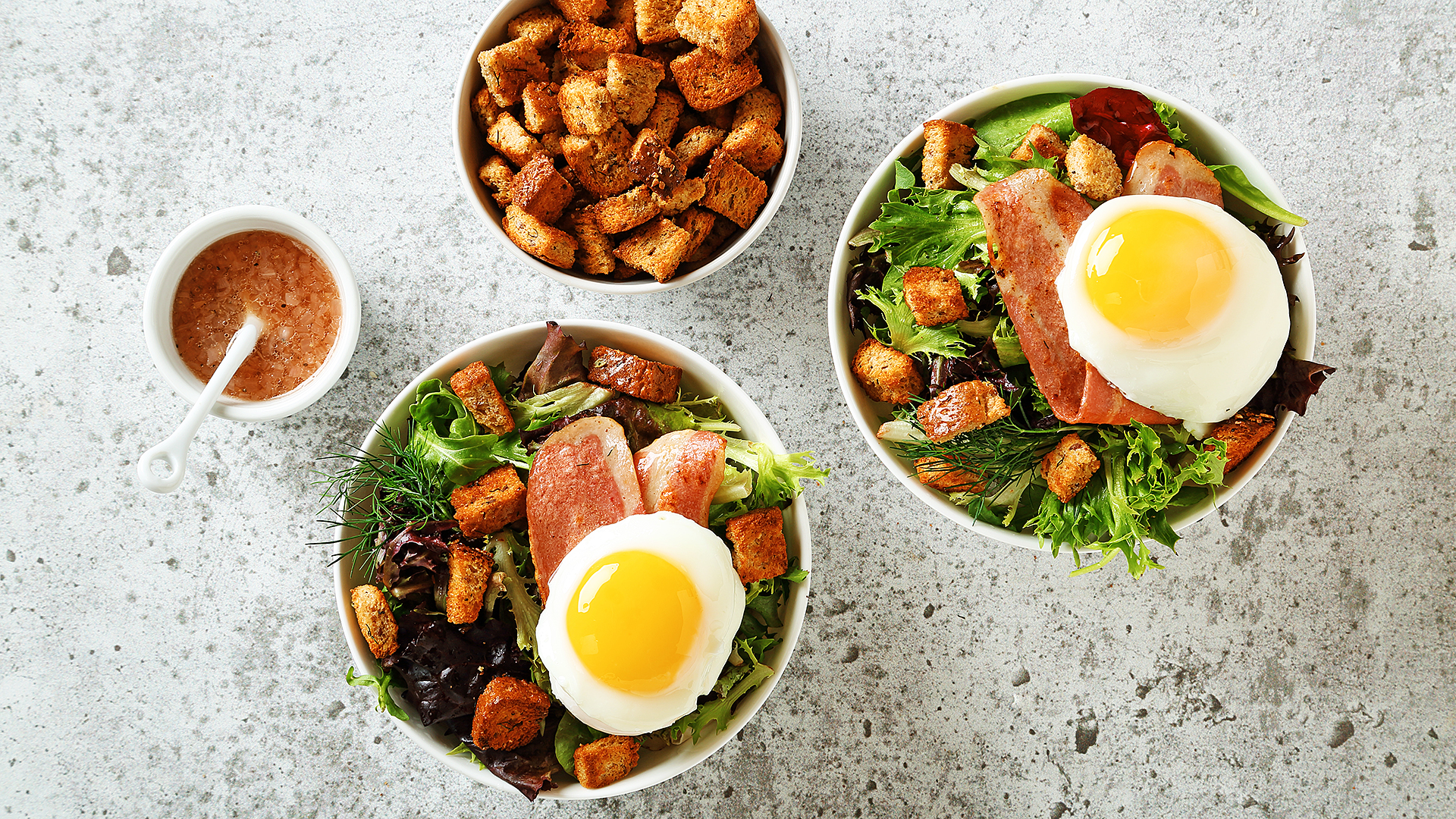 Salade de bacon à la dinde avec un œuf sur le côté et un bol de croûtons sur le côté.