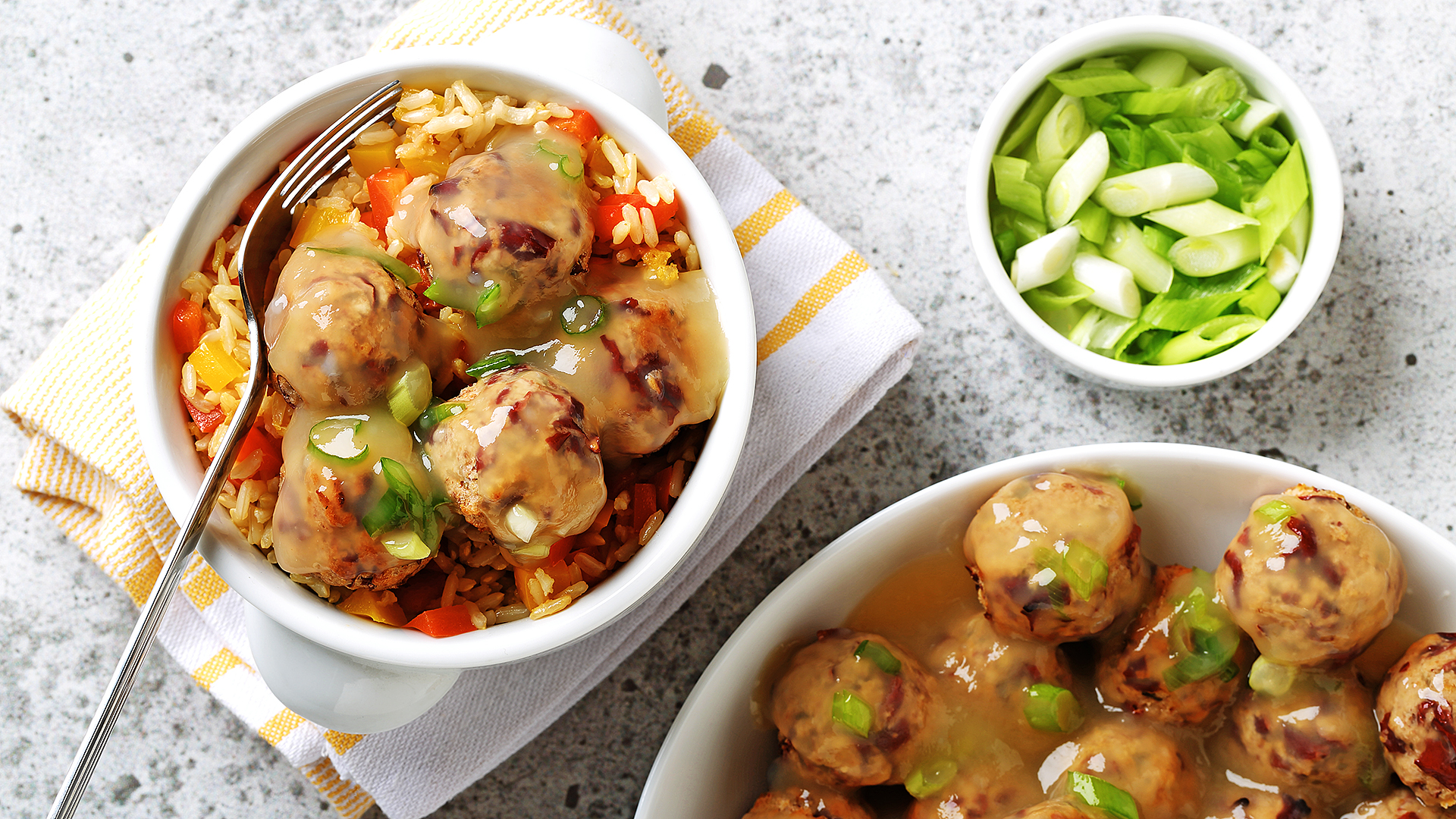 «Boulettes de viande» de haricots rouges sur du riz poivré avec des échalotes hachées sur le côté.