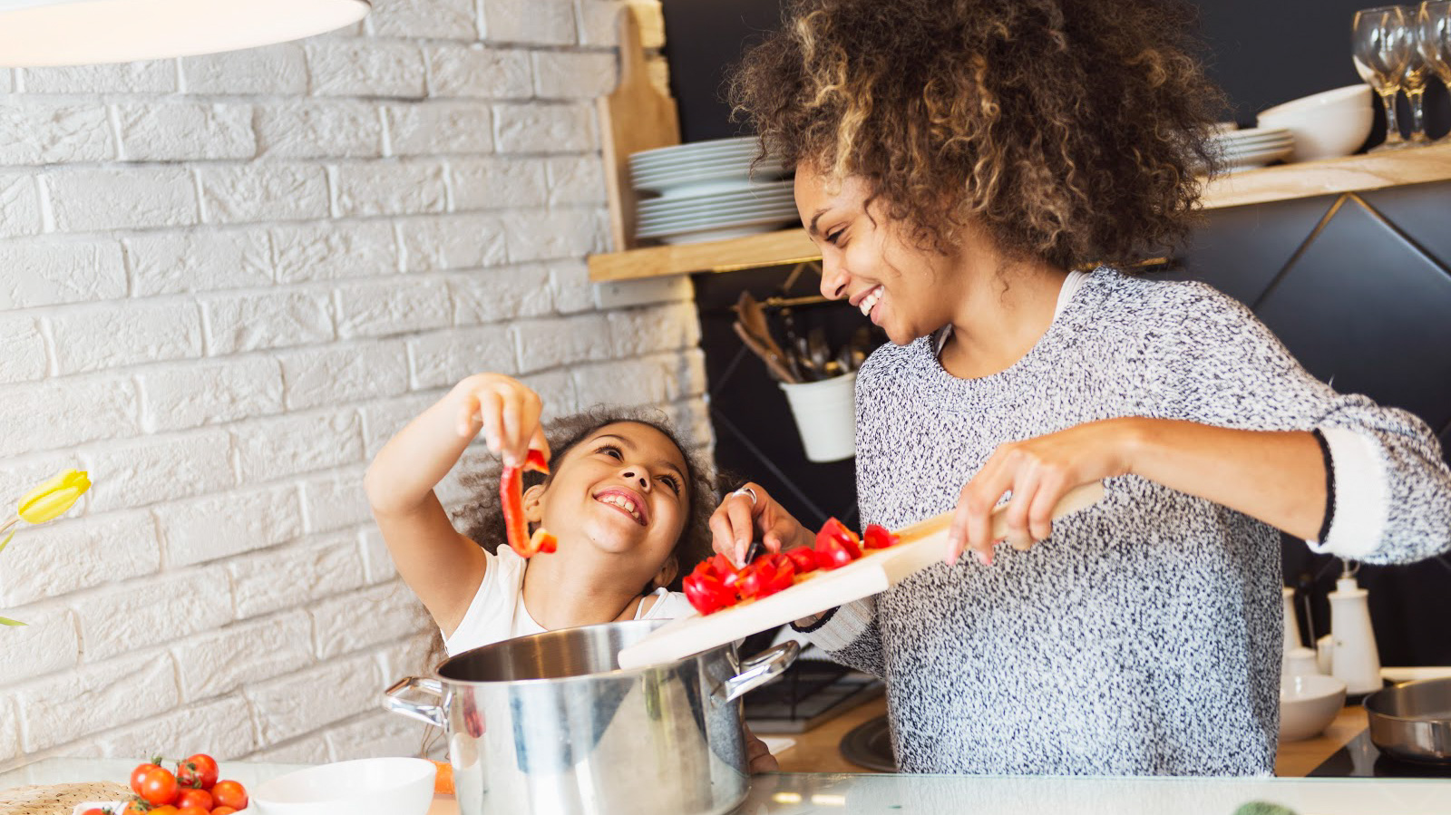 Une femme et sa fille apprêtant des légumes dans la cuisine.