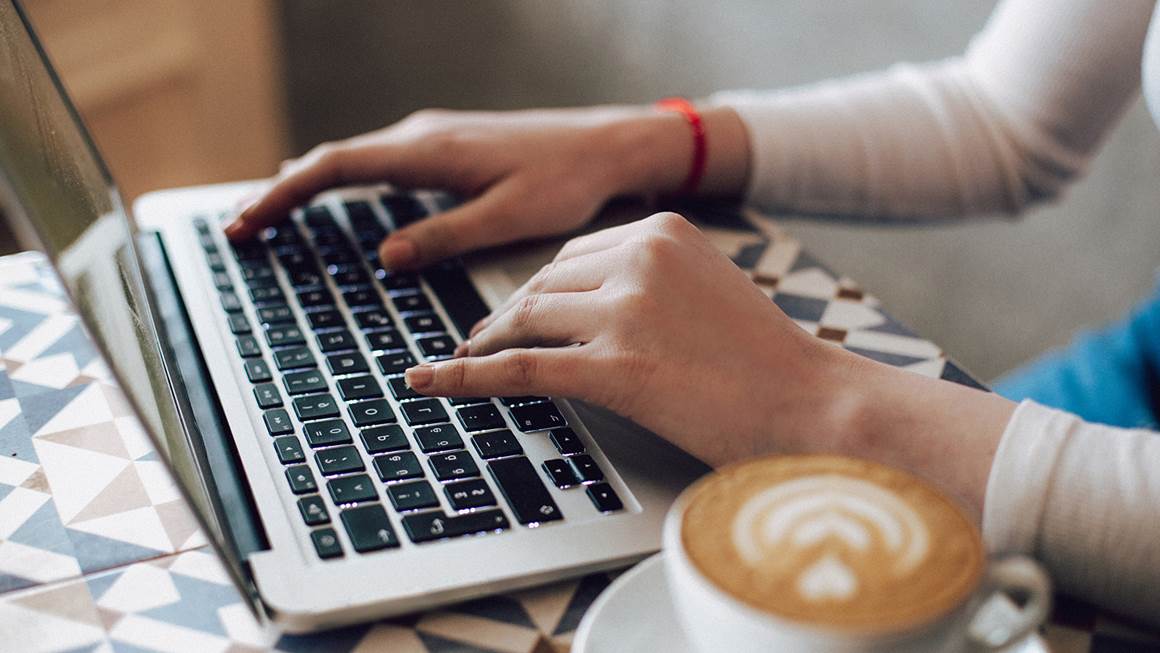 Femme avec un ordinateur portable et un café