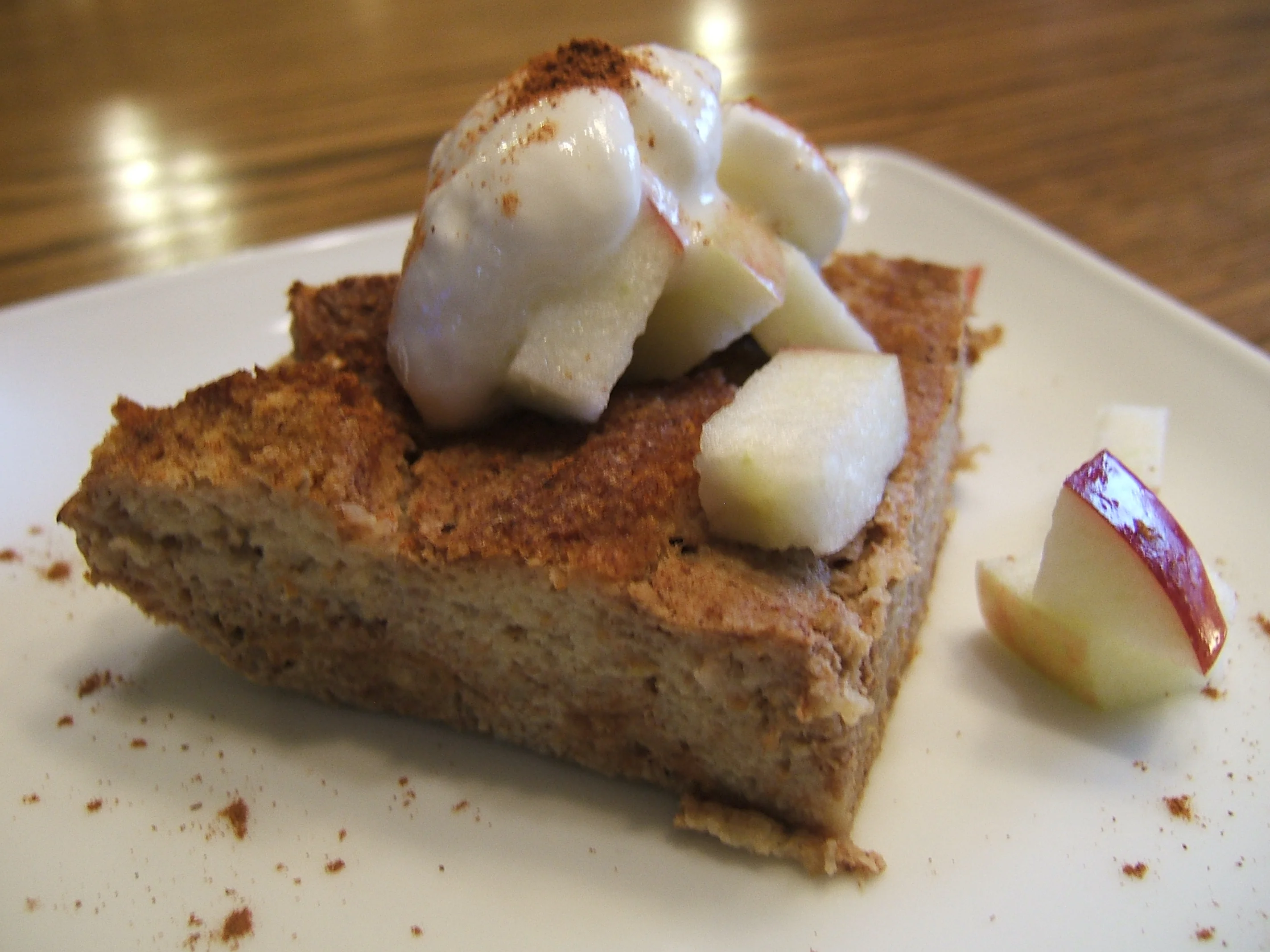 Une portion de pouding au pain cannelle avec pomme sur le dessus.