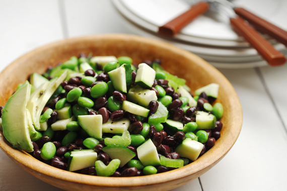 Salade aux haricots noir, edamames et avocat dans un bol de bois