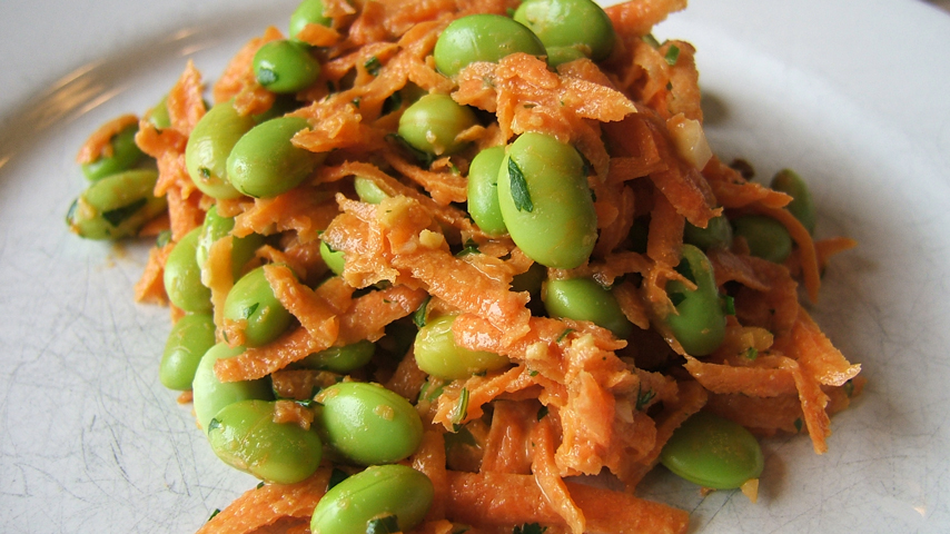 Salade à la carotte et à l’edamame sur une assiette blanche