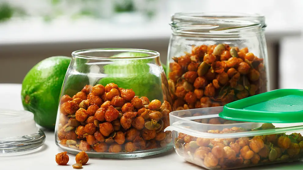 Deux bocaux en verre remplis de pois chiches croustillants, de la chaux en arrière-plan