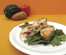 Frittata amusante sur un lit de verdure sur une assiette blanche, avec une arrière-plan orange