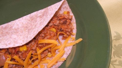Tacos à la dinde et aux haricots sur une assiette verte