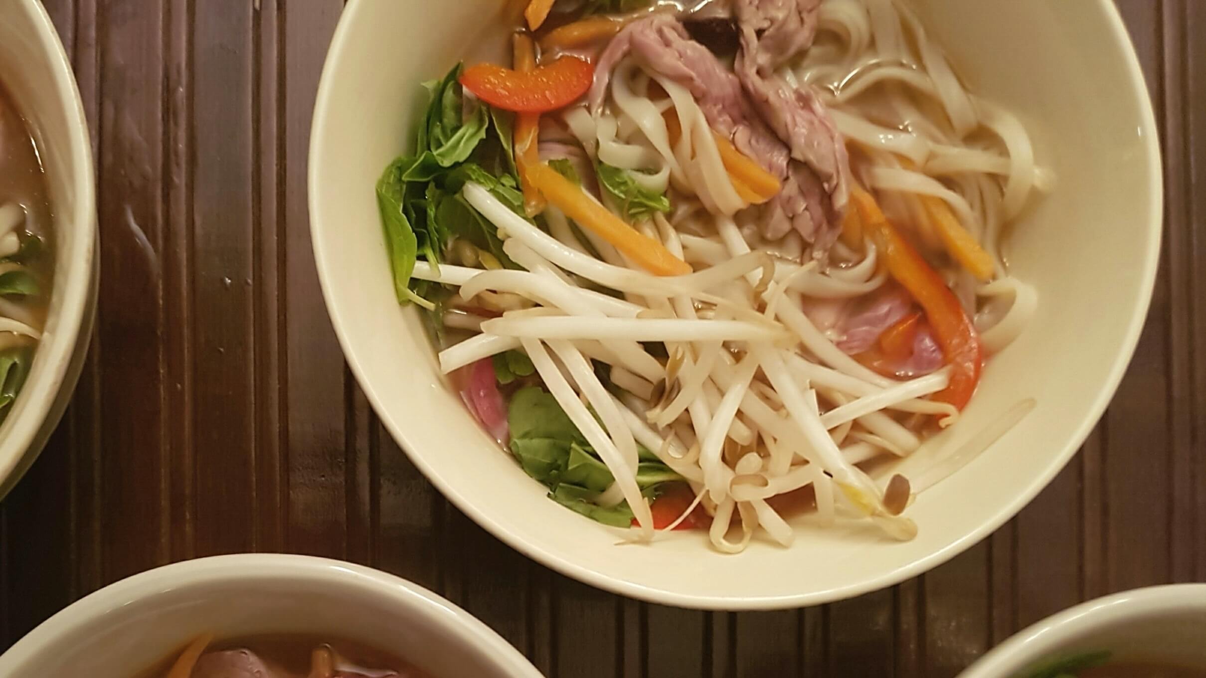 Bol de nouilles, becs de haricots, boeuf, épinards à la poitrine rouge et bouillon