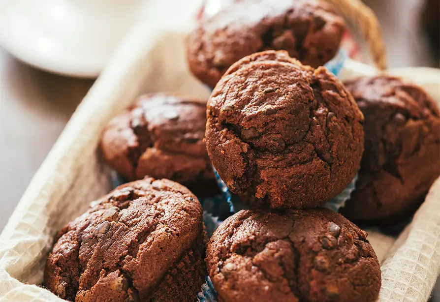 Un panier rempli de muffins à l’orge, aux cerises et au moka.
