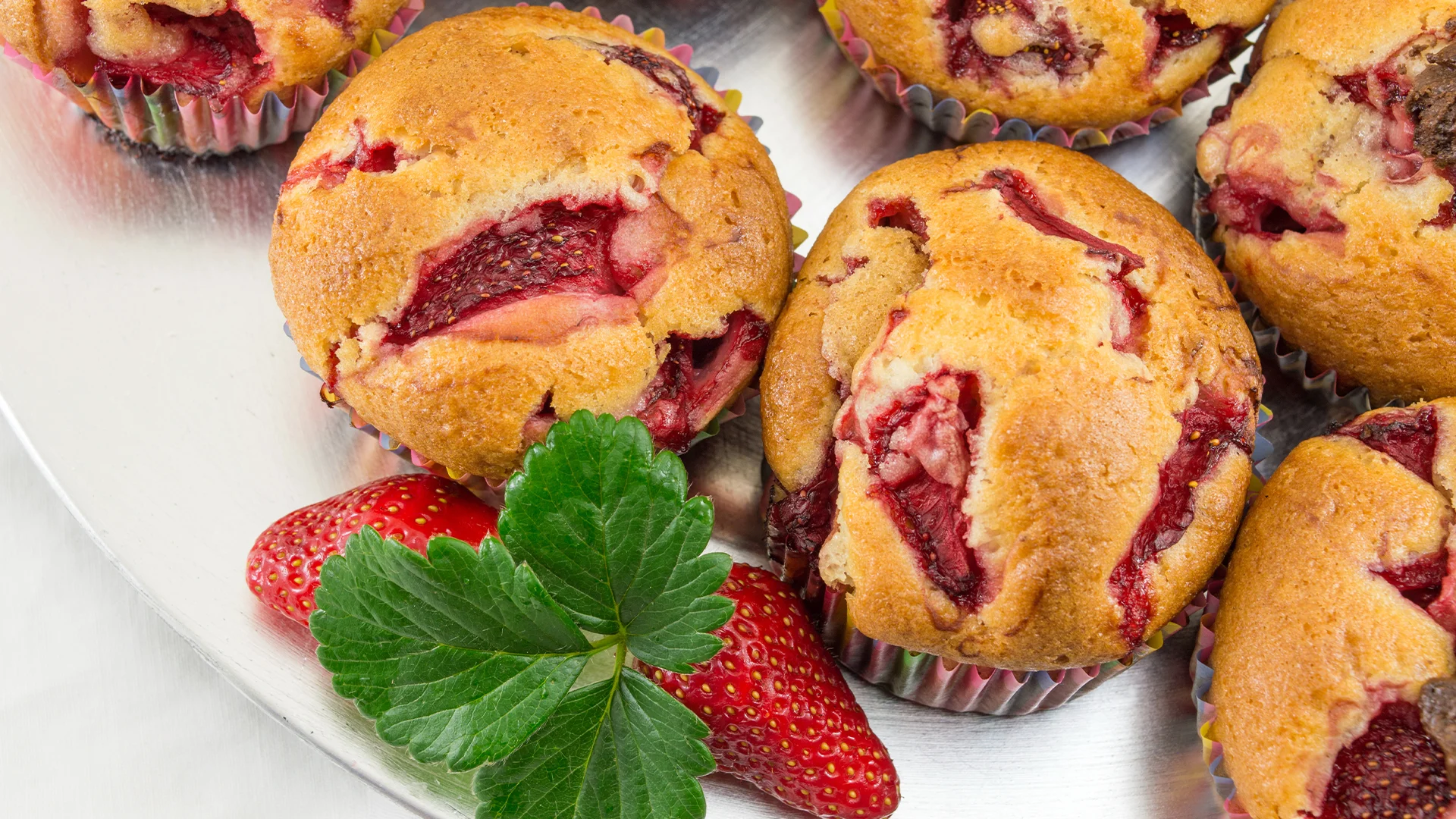 Muffins aux fraises sur une assiette blanche.