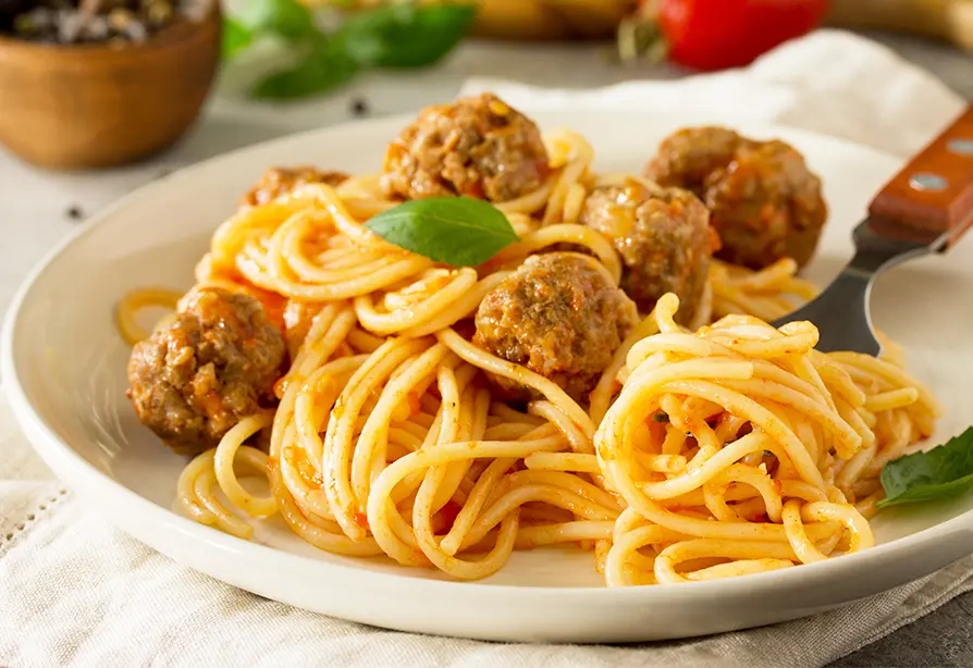 Un plat de spaghetti et de boulettes de dinde et une fourchette