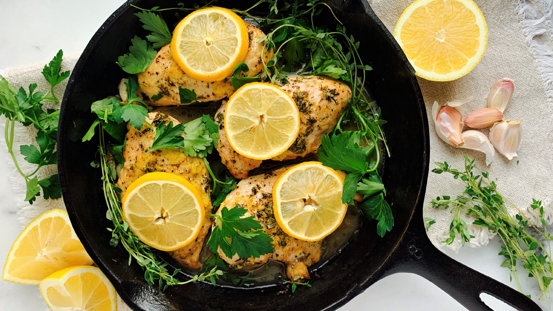 Des poitrines de poulet décorées de tranches de citron dans une poêle