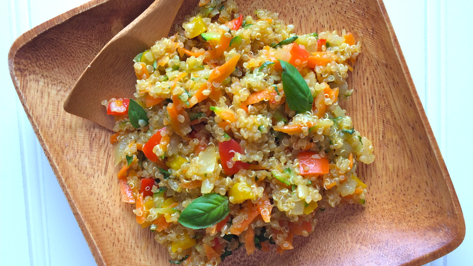  Confettis de légumes quinoa sur une assiette en bois et une cuillère en bois